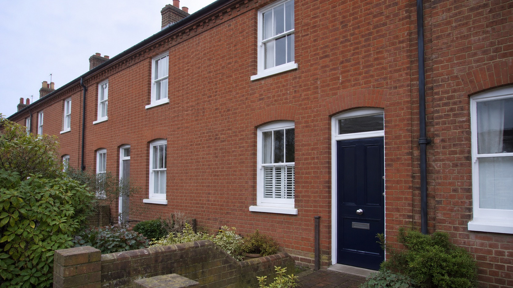 Illustrative visualisation of a brick terrace with white painted timber windows and navy door